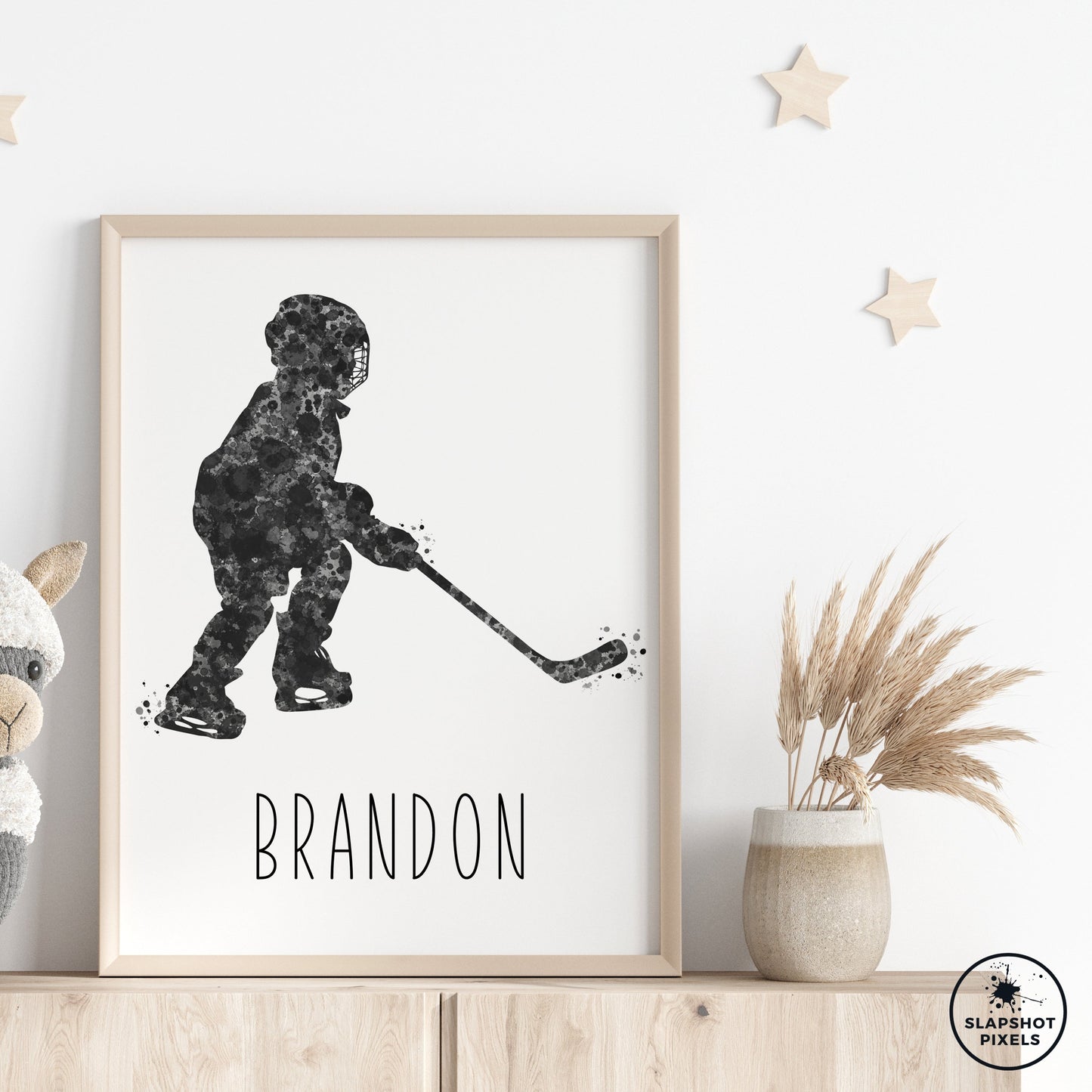 Personalized hockey poster of a child hockey player holding a hockey stick with custom name under the player. Designed in black and grey watercolor splatters. Perfect hockey gifts for boys, hockey team gifts, hockey coach gift, hockey wall art décor in a hockey bedroom and birthday gifts for hockey players.